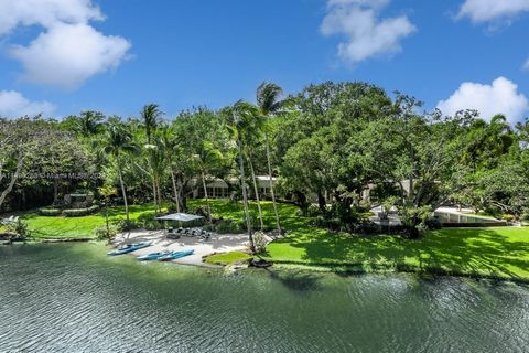 Sprawling 11,734 total SF lakefront estate in the prestigious guard-gated community of Snapper Creek, with unparalleled luxury and 5-BD, 5-BA and 2-HB. Over 1.5 lushly landscaped acres, with 313 trees, a private beach and 2 fire pits. Infinity saltwa...