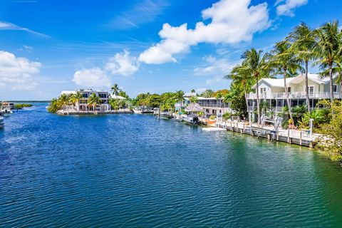 In the heart of Plantation Key lies a magnificent custom-built five bedroom. five bathroom waterfront home with a guest home, like no other. This resort-style oasis, crafted with the unyielding strength of CBS construction, and all impact glass windo...