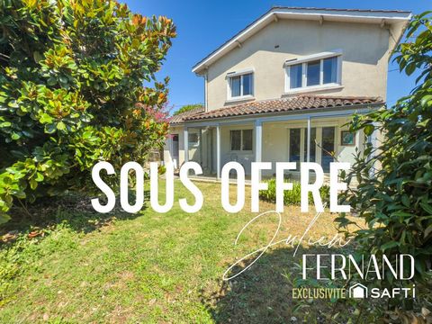 Maison à étage avec garage, véranda et jardin.