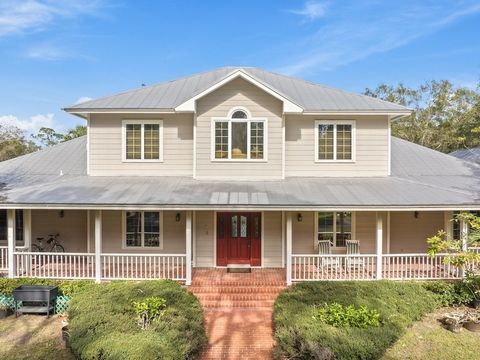 This stunning two-story home is set on a private 7-acre property. The house boasts 6 brm & 4.5 baths. A charming wraparound front porch welcomes you into the well-designed 4400+ living space. The main level features 2 suites: a primary suite & a moth...