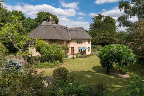 This charming Grade II listed former hall house, a typical English thatched cottage set in bucolic English countryside surrounded by fields and ancient snowdrop and bluebell woods, is a traditional yet modernised four-bedroom home dating to circa 16t...