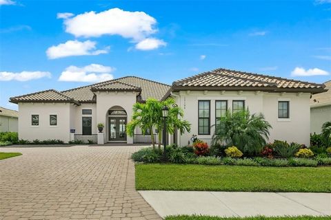Exemplifying luxury at its finest, this opulent, deeded golf home on a spacious ninety-foot lot occupies a coveted location on the 13th hole of the esteemed Esplanade at Azario golf course in Lakewood Ranch. As you enter through the glass double fron...