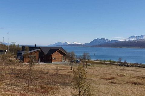 Modernes Ferienhaus von 2022 mit herrlichem Panoramablick zum Wasser Richtung Norden, zur Insel Nord-Fugløya und zur Mitternachtssonne! Das leicht abschüssige Naturgrundstück bietet zudem ein Wandergebiet direkt vor der Tür. Wanderziele in der unmitt...