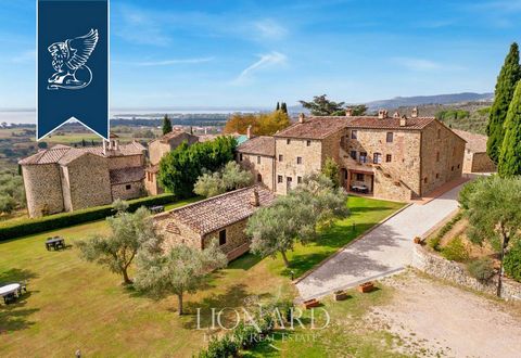 Extraordinary ancient village for sale on the top of a sweet hill overlooking the suggestive Lake Trasimeno in Umbria, on the border with Tuscany. Once ancient Borgo, now has been transformed into a characteristic relais that houses 17 elegant apartm...