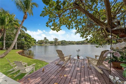 Privacy gates open to a deep lake-front acre and private oasis in South Gables, minutes from top schools and the South Miami town center. A long drive, framed by an expansive front lawn, leads to the one story home set far back from the street. Brigh...