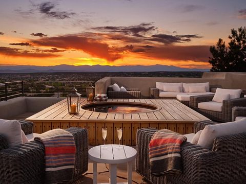 Panoramic views of Santa Fe and the Jemez, Sandia, and Ortiz Mountains. Spectacular sunrises and sunsets only 5 minutes from Canyon Road and The Plaza. Modern minimalism meets Pueblo Revival. Meticulous, move-in ready collaboration between a green de...