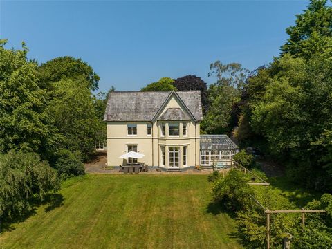 Ground Floor Turning into the drive off the lane is like a mystery tour as you pass light woods and rhododendrons. Suddenly, the twin gable house and offset conservatory appear round the corner where there is ample parking in front with a double gara...