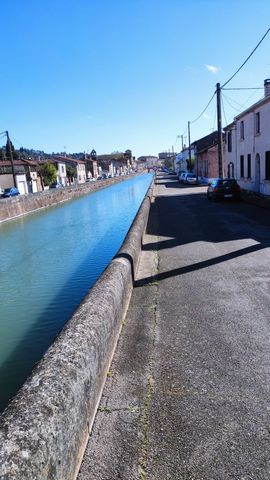 This bright house facing S/E is located in a quiet area, on the banks of the Canal du Midi.It is composed on the ground floor, of an entrance to the living room/lounge and a spacious, fully equipped kitchen separate, wc.The first floor includes two b...