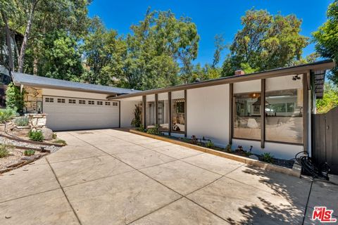 In prime Woodland Hills, south of the Blvd, down a long private driveway is this remarkably private and beautifully updated Mid-Century gem. Experience the warmth as you enter an amber lit open concept living room with timeless Terrazzo tiles, built ...