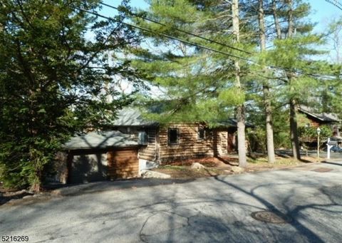 This one of a kind home in the Pine Lakes section of Wayne is a custom antique log cabin built and cared for by the current owner. It boasts unique features such as 4 sky lights, stain glass windows, and a loft sleep space. House also includes 2 addi...