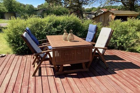 Ferienhaus in einer ruhigen Straße mit Trampelpfaden und kleinen Wegen zum nahen Strand und zu den Gaststätten in der Umgebung. Die Terrasse des Hauses erstreckt sich entlang drei Seiten der Unterkunft. Im Außenbereich stehen Gartenmöbel, eine Feuers...