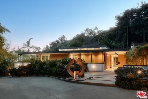 Designed by renowned architect Rex Lotery, FAIA, in 1959, this mid-century masterpiece in the prestigious Trousdale Estates has been meticulously restored to honor its original vision. Commissioned by French actress Corinne Calvet and shaped by a ser...